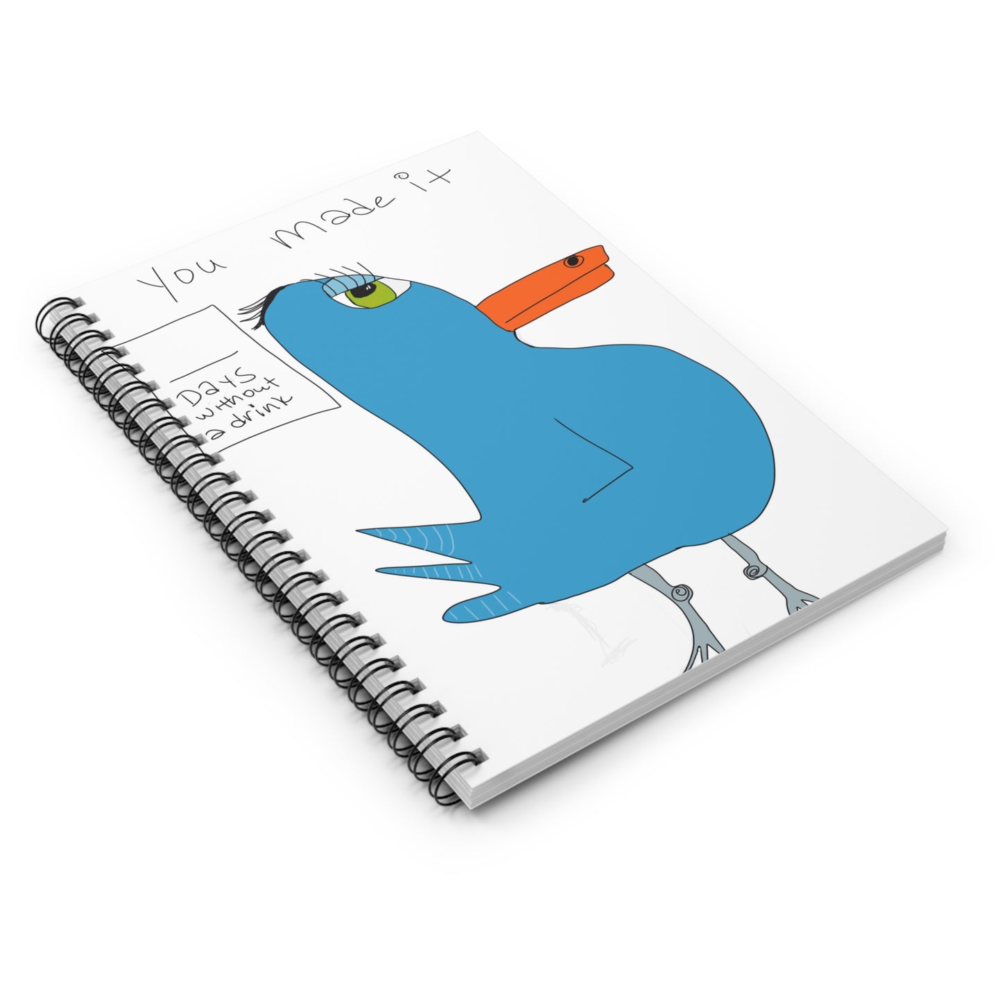 The Printify Recovery Celebration - Spiraled Notebook- Ruled Line is a 6"x8" notebook with a cartoon blue bird and "You made it" plus "Days without a drink" on the cover. Features ruled line paper for your notes.