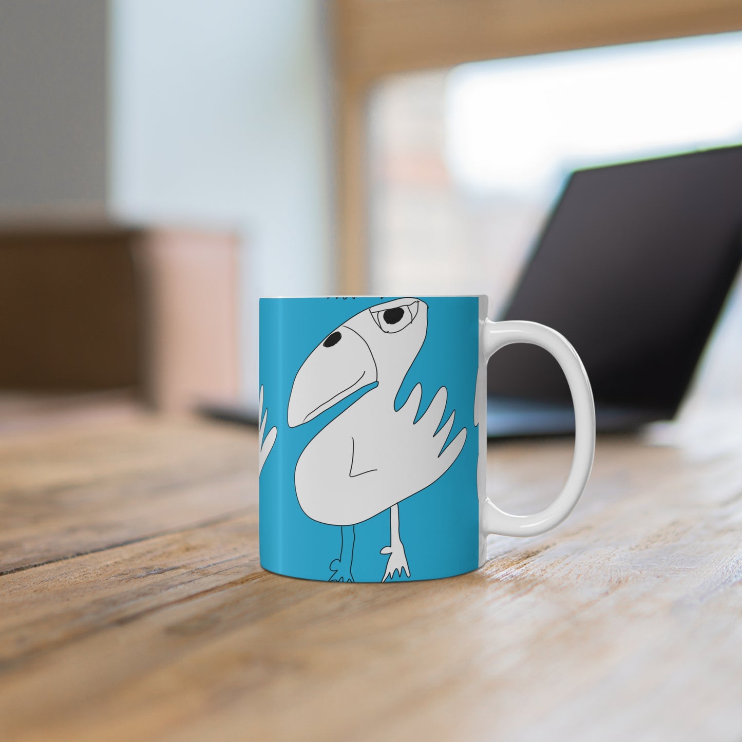 The 1:1 - Mug - 11oz by Printify is a blue ceramic mug featuring a quirky cartoon white bird, shown on a wooden table with a laptop and window in the background—perfect as a fun sobriety or recovery gift.
