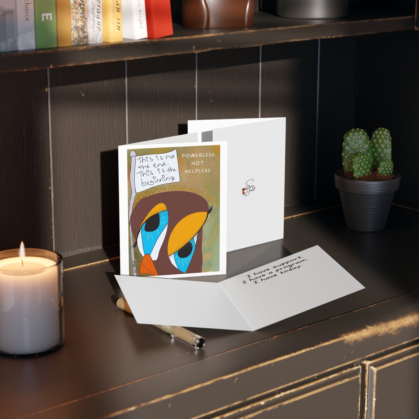 The Printify Greeting Cards Set - Powerless, not helpless features inspirational support messages and a sad bird illustration. Available in sets of 8, 16, or 24 pcs, these cards radiate positivity on any desk beside a candle or cactus.