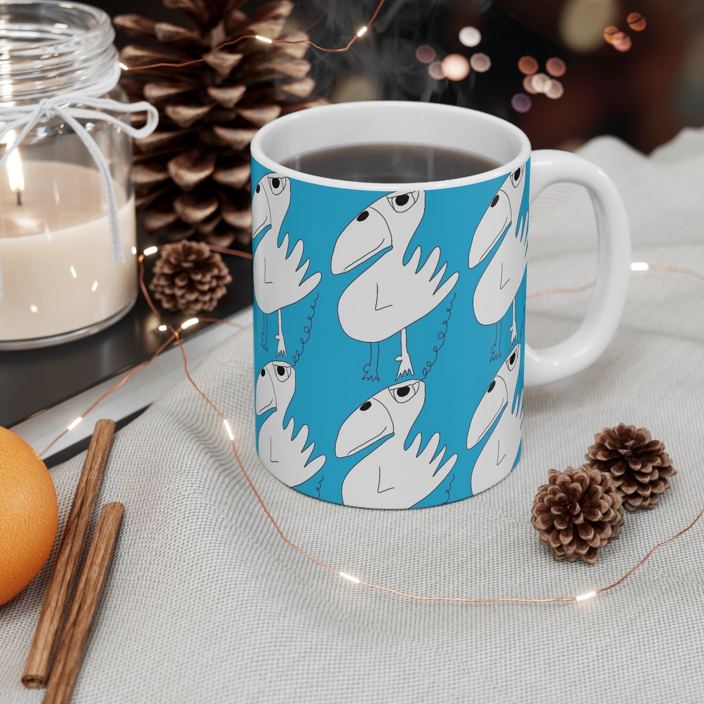 The One Among Many Mug - 11oz by Printify, a quirky white ceramic cup featuring bird illustrations, sits on a table with festive decor and steaming coffee against a blue backdrop.