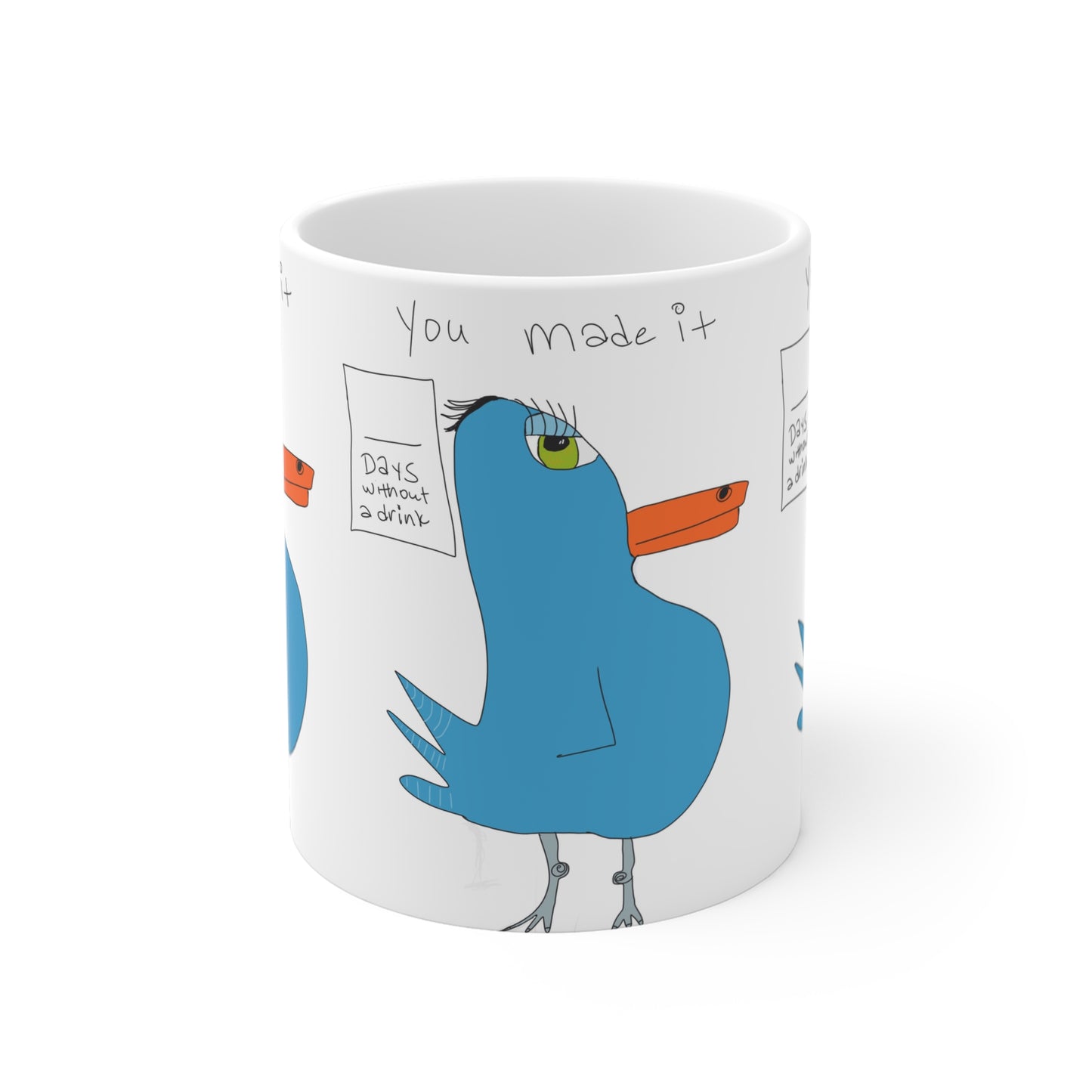 The Recovery Celebration Mug - 11oz by Printify is a whimsical ceramic coffee mug with a cartoon blue bird, orange beak, and green eye. Featuring the phrase "You made it," it's a perfect gift for sober lifestyle encouragement and support.