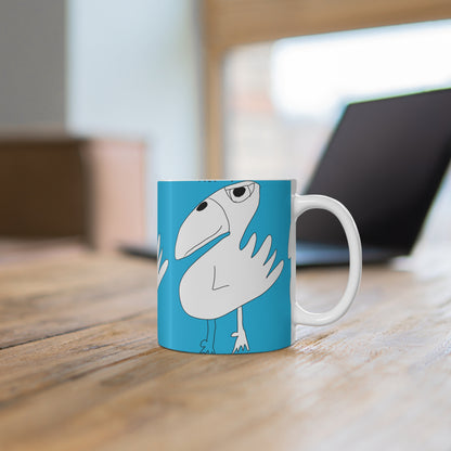 The 1:1 - Mug - 11oz by Printify is a blue ceramic mug featuring a quirky cartoon white bird, shown on a wooden table with a laptop and window in the background—perfect as a fun sobriety or recovery gift.