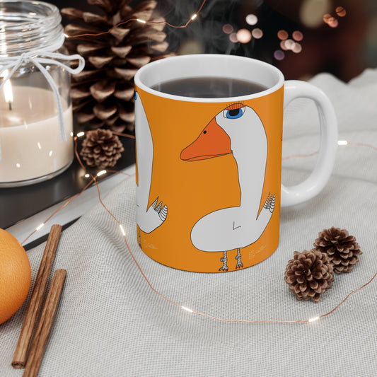 The 11oz Duck Mug by Printify features a white ceramic design with a goose illustration on orange, pictured amid pinecones, a candle, cinnamon sticks, an orange, and string lights—an uplifting sobriety gift with steam rising from a hot drink.